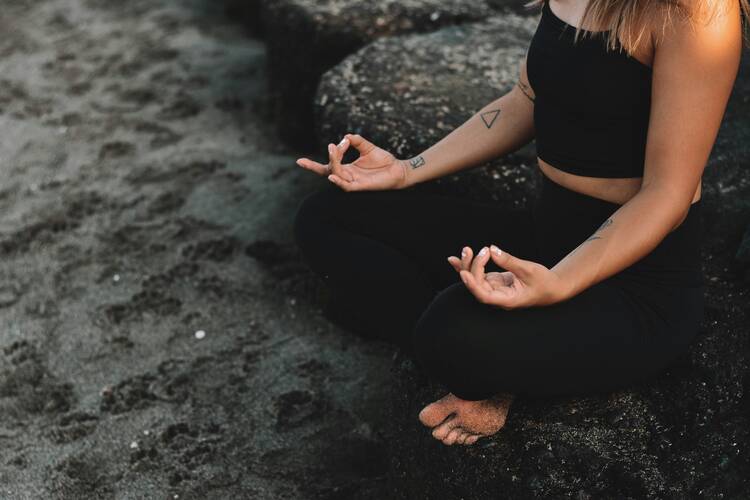 Woman meditating in sand